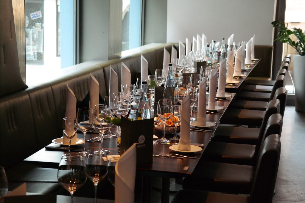 Mesa de un restaurante con cubiertos, copas, agua y pan